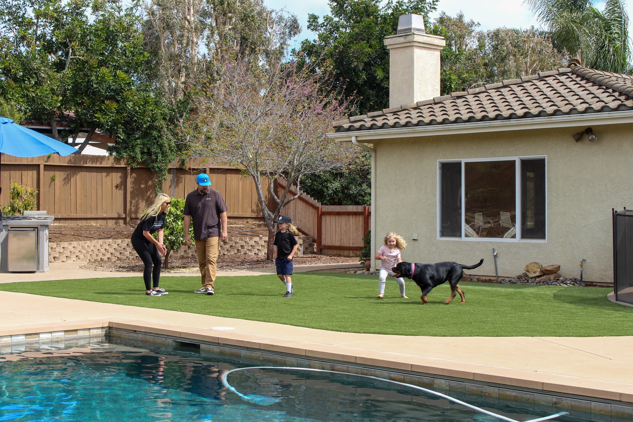 Family with dog on turf lawn